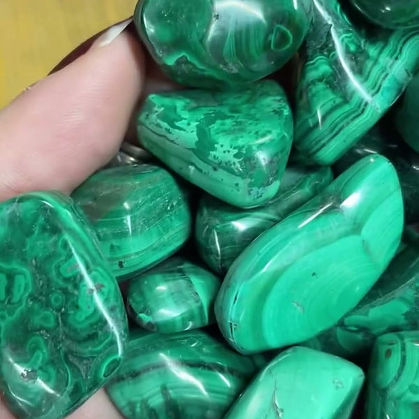 A handful of polished malachite tumbled stones