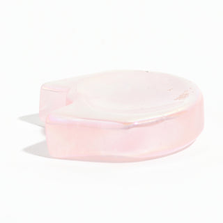 Rose Quartz Aura-Plated Cat Head Bowl seen from the side, showing the shallow carved hollow and the pink quartz body, on a clean white background. Stonebridge Imports.