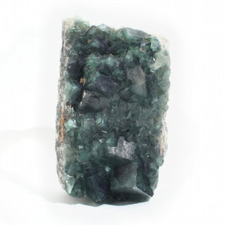 Fluorite Cluster Unique #54 viewed end-on, showing stepped teal-green fluorite cubes and darker blue-green crystal faces, photographed on a clean white background. Stonebridge Imports.