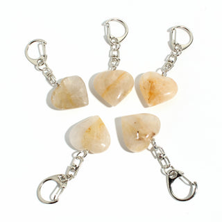 Golden Healer Heart Charm - Pack of 5 - five polished peach-gold golden healer hearts, each on its own silver-tone swivel clasp, arranged on a clean white background. Stonebridge Imports.