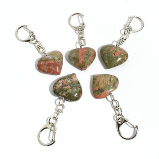 Unakite Heart Charm - Pack of 5 - five polished green-and-salmon unakite hearts, each on its own silver-tone swivel clasp, arranged on a clean white background. Stonebridge Imports.