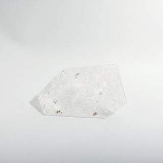 Clear Quartz Free Form Unique #1, a polished clear quartz free-form polished point showing internal veils and rainbow inclusions, photographed on a clean white background. Stonebridge Imports.