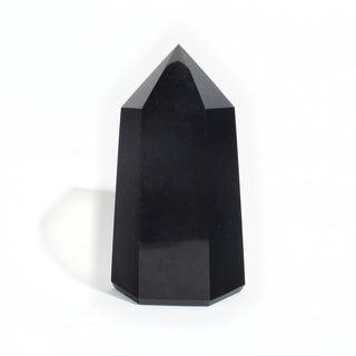 Black Obsidian Generator Unique #3 — polished six-sided tower rising to a faceted point, glossy jet-black faces, photographed on a clean white background. Stonebridge Imports.