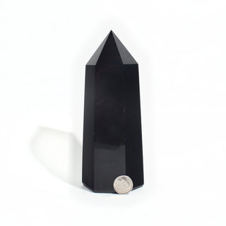 Black Obsidian Generator Unique #10 — polished six-sided tower with a faceted point, beside a Canadian dime for scale, photographed on a clean white background. Stonebridge Imports.