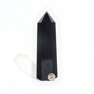 Black Obsidian Generator Unique #11 — polished six-sided tower with a faceted point, beside a Canadian dime for scale, photographed on a clean white background. Stonebridge Imports.