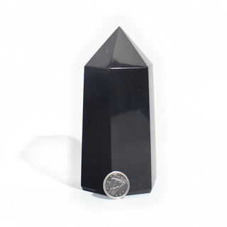 Black Obsidian Generator Unique #13 — polished six-sided tower with a faceted point, beside a Canadian dime for scale, photographed on a clean white background. Stonebridge Imports.