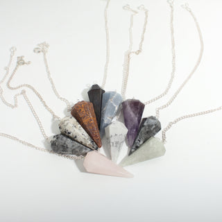 Mixed Stone Pendulums 10-Pack, an assortment of faceted crystal point pendulums with silver chains fanned together on a clean white background. Stonebridge Imports.