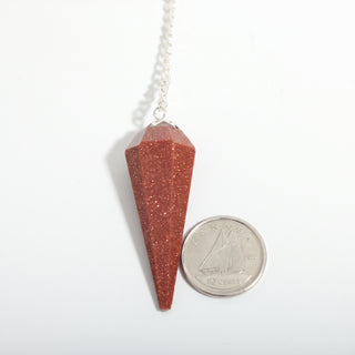 Brown Goldstone Pendulum 6 Facet & Bead - 3 Pack, one red-brown sparkling goldstone pendulum beside a dime for scale, on a clean white background. Stonebridge Imports.