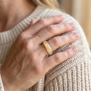 Golden Healer Ring worn on the hand in natural light, showing the solid pale golden healer quartz band at true scale.