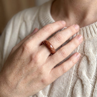 Brown Goldstone Ring (Enhanced) worn on the hand in natural light, showing the solid brown goldstone with copper sparkle band at true scale.