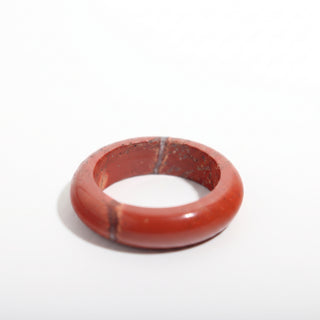 Red Jasper Ring — solid brick-red red jasper stone band ring, alternate angle photographed on a clean white background. Stonebridge Imports.
