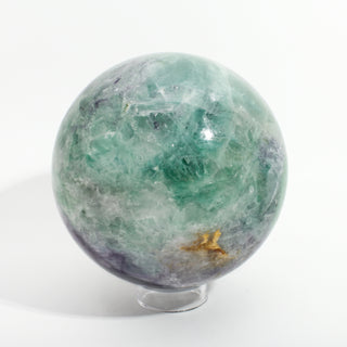 Fluorite Green and Purple Sphere Unique #12, alternate angle showing green and purple fluorite with a golden-brown inclusion, on a clean white background. Stonebridge Imports.