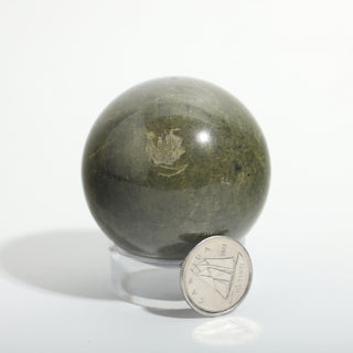 Extra Small #2 — Vessonite Sphere, deep olive green with lighter green and gold veining beside a Canadian dime for scale, photographed on a clean white background. Stonebridge Imports.