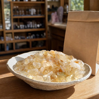 Citrine A Tumbled stones - Free Form - 1/2 lb (Enhanced) in a ceramic bowl on a shop counter
