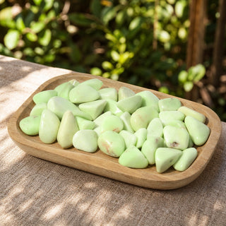 Citron Chrysoprase Tumbled Stones in a wooden tray at a market stall