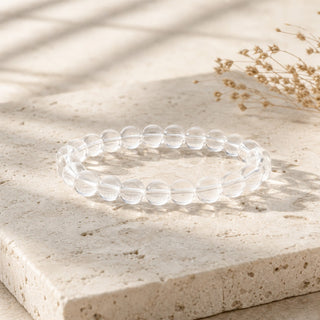 Clear Quartz bead bracelet resting on a stone slab