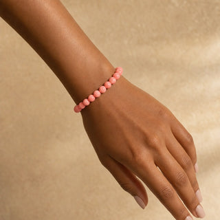 Pink Coral bead bracelet worn on the wrist, close-up