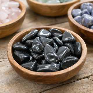 Hematite Tumbled Stones in a wooden bowl on a boutique display table