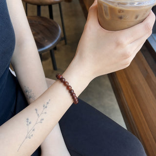 Brecciated Jasper bead bracelet worn on a tattooed forearm holding a coffee
