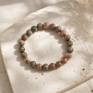 Leopardskin Jasper bead bracelet resting on a stone slab