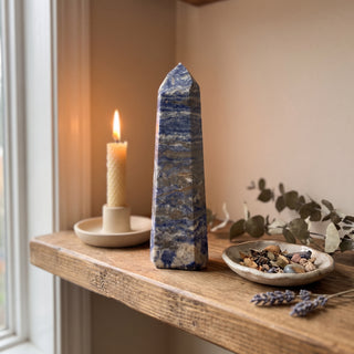 Sodalite Generator Unique #19 displayed on a wooden home altar shelf beside a candle, shown at true size in warm natural light.