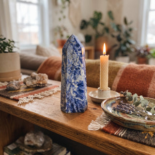 Sodalite Generator Unique #20 displayed on a wooden home altar shelf beside a candle, shown at true size in warm natural light.