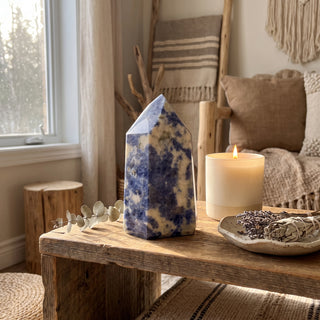 Sodalite Generator Unique #12 displayed on a wooden home altar shelf beside a candle, shown at true size in warm natural light.