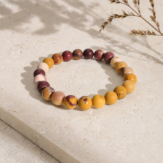 Mookaite Jasper bead bracelet resting on a stone slab