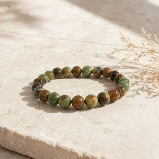 Opal bead bracelet resting on a stone slab
