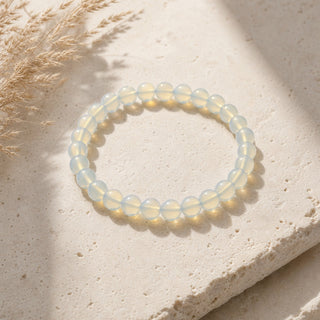 Opalite bead bracelet resting on a stone slab