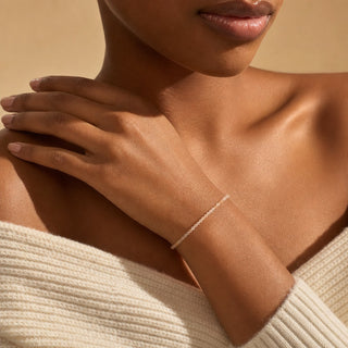 Sunstone bead bracelet worn with the fingertips resting at the collarbone